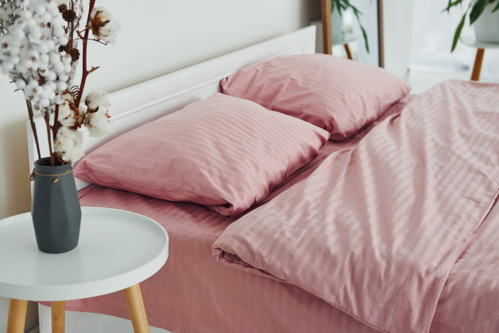 Pink colored bed. Interior and design of beautiful modern bedroom at daytime.
