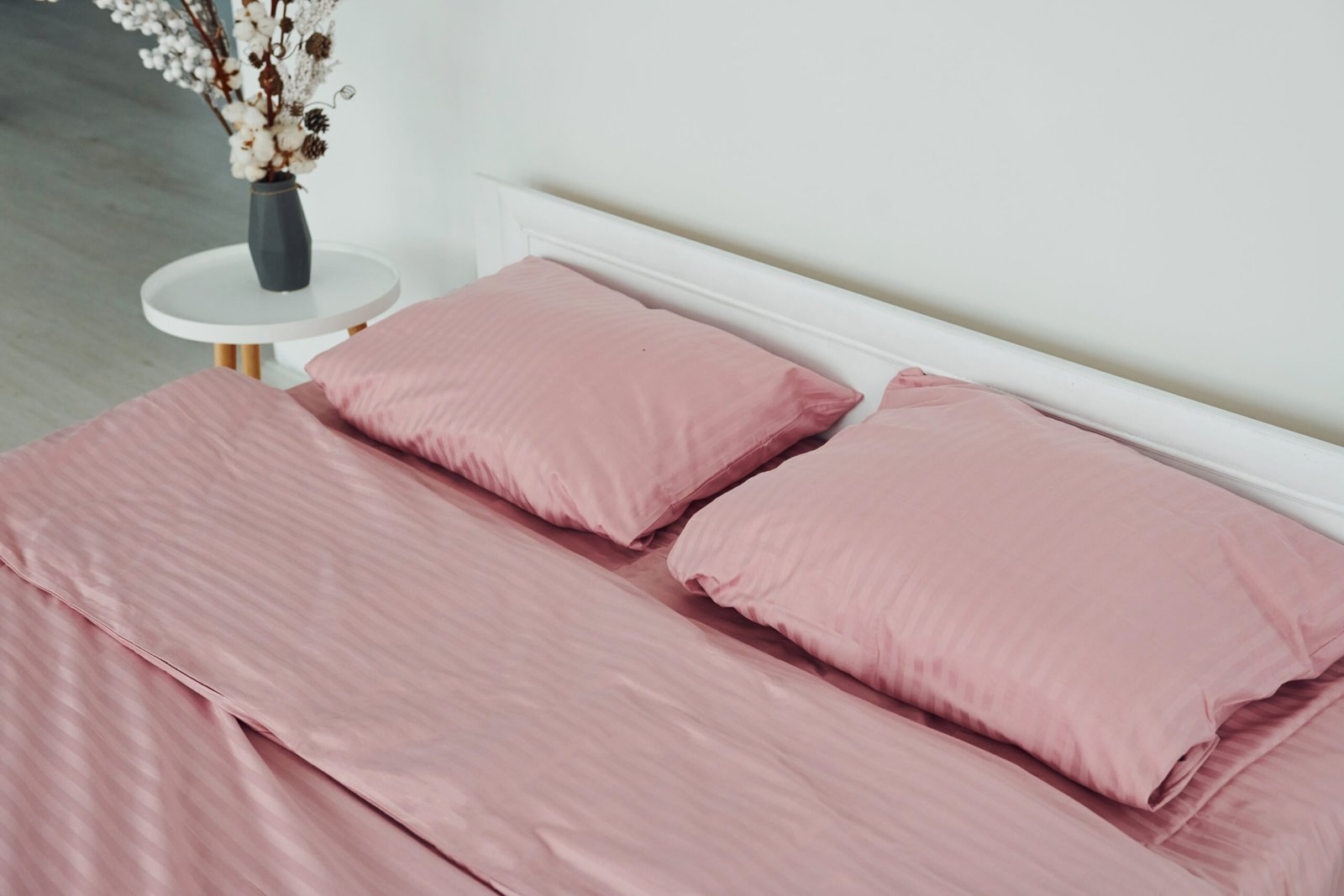 Pink colored bed. Interior and design of beautiful modern bedroom at daytime.
