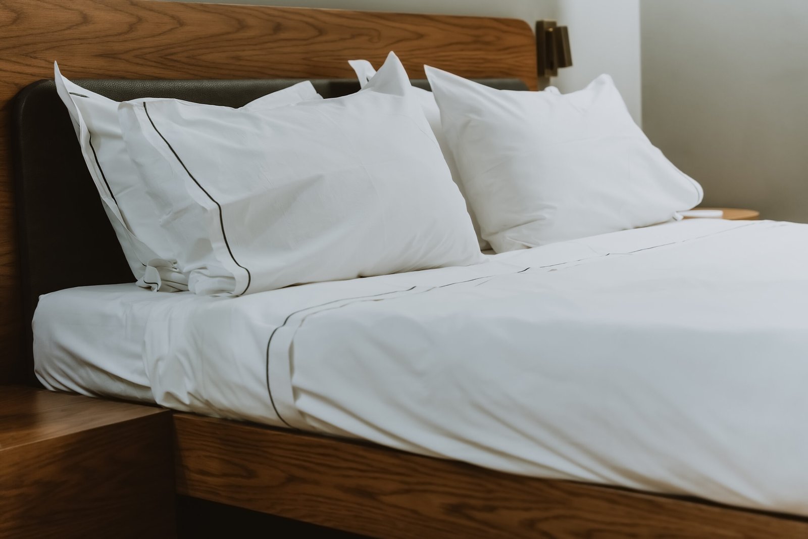 White pillows and sheets in a bedroom in a beauty salon. Close. Large double bed for comfortable sleep and relaxation. Modern comfortable white cotton bed linen